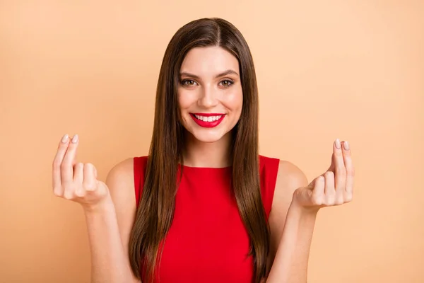 Фото щасливої позитивної молодої жінки роблять пальці гроші жестом запитайте зарплату ізольовано на пастельному бежевому кольорі — стокове фото