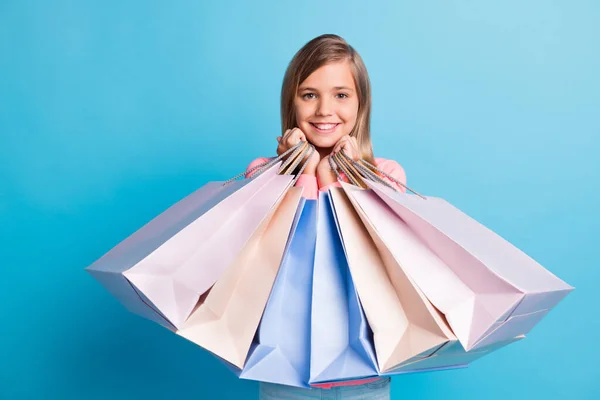 Fotoporträt von Mädchen mit Einkaufstaschen in der Nähe Gesicht lächeln isoliert auf pastellblauem Hintergrund — Stockfoto