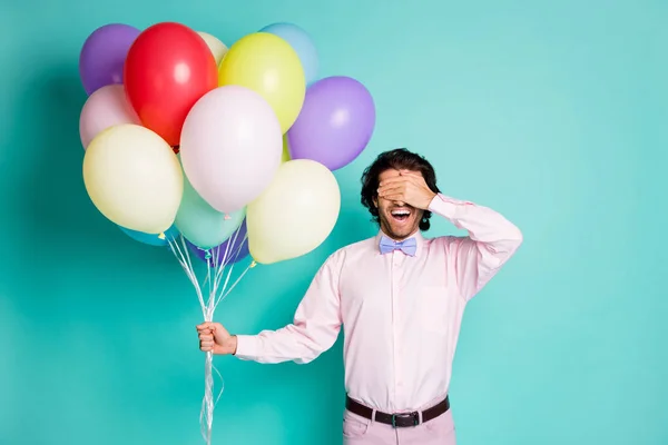 Retrato de hombre joven cubrir los ojos vestidos formalwear celebrar globos de colores fiesta sorpresa aislado color verde azulado fondo —  Fotos de Stock