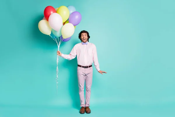 Foto em tamanho completo de feliz impressionado cara desgaste formal camisa calças arco segurar muitos balões isolado turquesa cor fundo — Fotografia de Stock