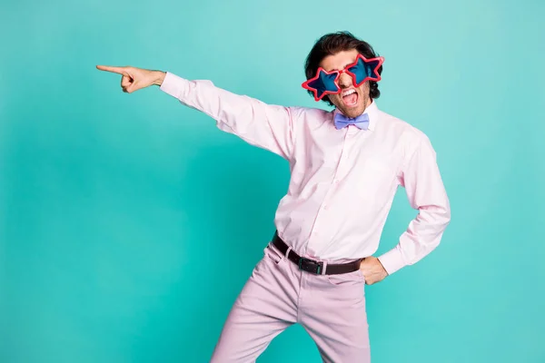 Foto di affascinante bruno ondulato capelli gentiluomo vestito camicia rosa danza puntando un dito vuoto spazio isolato colore sfondo turchese — Foto Stock