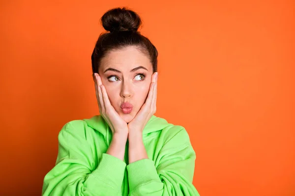 Fotoporträt schmollenden Mädchen berühren Gesicht Wangen mit zwei Händen isoliert auf lebendigen orangefarbenen Hintergrund — Stockfoto