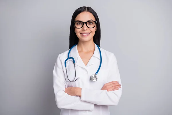 Foto de bonito mulher adorável terapeuta vestido branco uniforme óculos braços cruzados isolado cinza cor fundo — Fotografia de Stock
