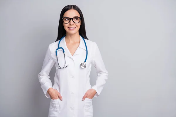 Photo of doctor girl hands pockets look empty space wear spectacles stethoscope white uniform isolated grey color background — Stock Photo, Image