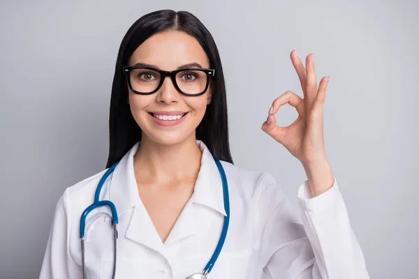 Foto von Arzt Dame demonstrieren okey Finger tragen Brille Stethoskop weiße Uniform isoliert graue Farbe Hintergrund — Stockfoto