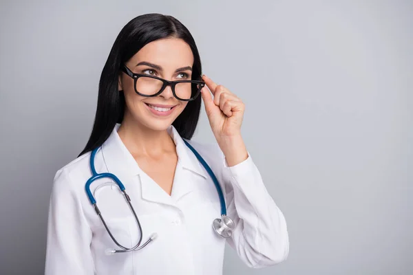 Foto do médico menina coquete olhar espaço vazio desgaste estetoscópio óculos branco uniforme isolado cinza cor fundo — Fotografia de Stock
