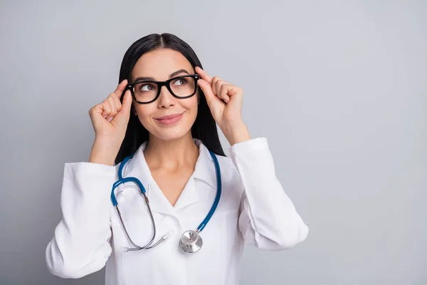 Foto von Arzt Dame suchen leeren Raum tragen Stethoskop-Brille weiß einheitlich isoliert graue Farbe Hintergrund — Stockfoto