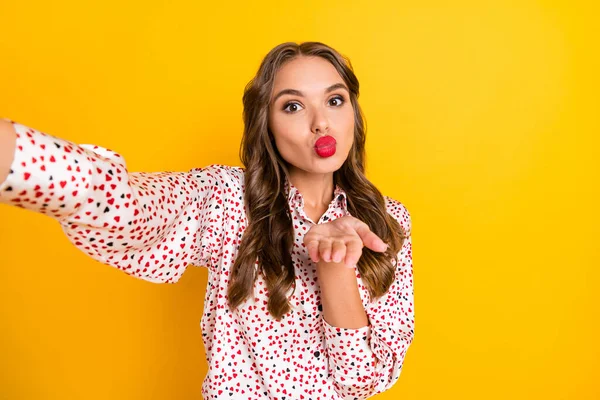 Foto von hübschen jungen Mädchen machen Selfie Arm senden Sie küssen tragen Herz Print Outfit isoliert auf gelbem Hintergrund — Stockfoto