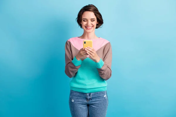 Foto porträtt av glad kvinna som håller telefonen i två händer isolerade på pastell ljusblå färgad bakgrund — Stockfoto