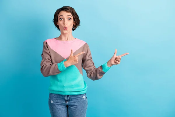 Foto portret van geschokte vrouw wijzen twee vingers naar lege ruimte geïsoleerd op pastel licht blauw gekleurde achtergrond — Stockfoto