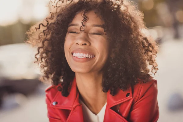 Foto van zoete grappige krullende vrouw gekleed rood gejacked lachen gesloten ogen buiten stedelijke stad straat — Stockfoto