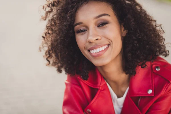 Foto van schattig zoet mooi krullend vrouw gekleed rood gejacked positief glimlachen buiten stedelijke stad straat — Stockfoto