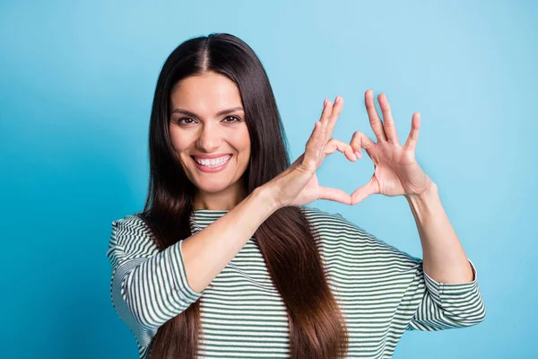 Retrato de atraente mulher braços dedos mostrar coração forma bom humor desgaste branco verde isolado no fundo de cor azul — Fotografia de Stock