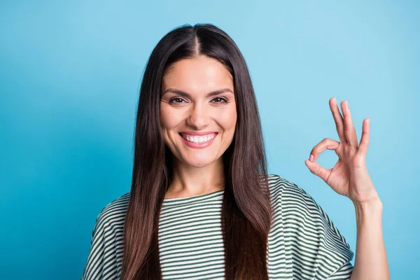 Retrato de pessoa alegre sorriso de dente mostrar dedos símbolo okey desgaste verde branco isolado no fundo de cor azul — Fotografia de Stock