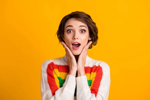 Foto van schattig verrast jong meisje armen gezicht wangen gezicht open mond slijtage gestreepte trui geïsoleerde gele kleur achtergrond — Stockfoto
