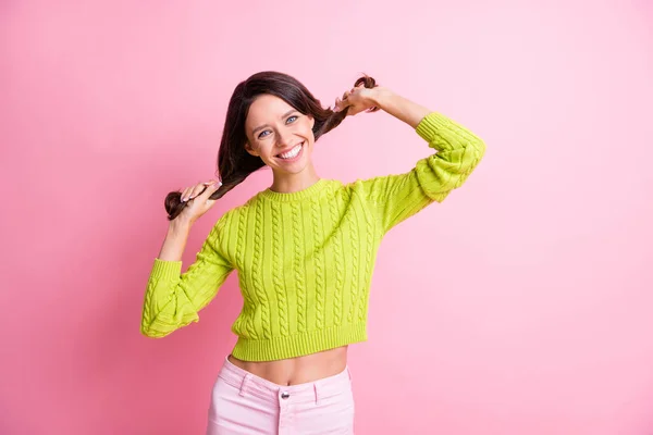 Foto di carino infantile ondulato signora indossare verde maglione braccia tenendo i capelli isolati pastello colore rosa sfondo — Foto Stock