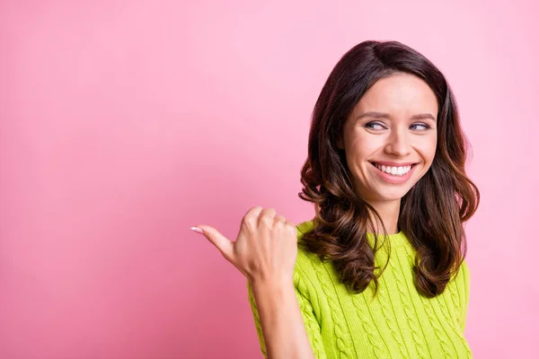 Fotografie legrační veselá mladá dáma ukazují palec vzhled prázdný prostor oblečení zelený svetr izolované růžové barvy pozadí — Stock fotografie