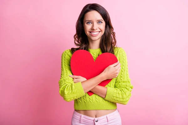 Foto da linda menina radiante sorriso abraçar vermelho papel coração figura desgaste verde pulôver isolado cor rosa fundo — Fotografia de Stock