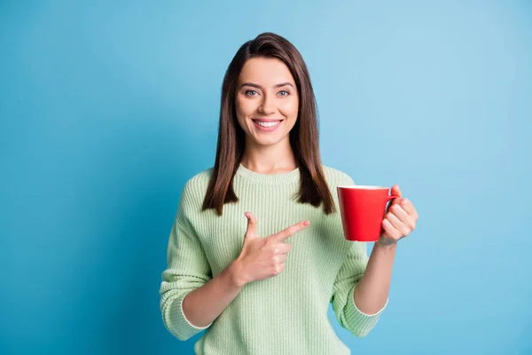 Foto gadis positif ceria titik indeks cangkir jari memakai pullover terisolasi atas warna biru latar belakang — Stok Foto