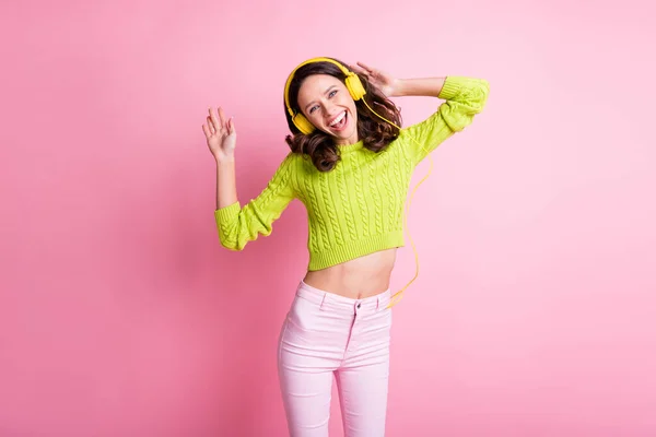 Photo of adorable wavy lady wear green sweater listening music earphones dancing isolated pastel pink color background — Stock Photo, Image