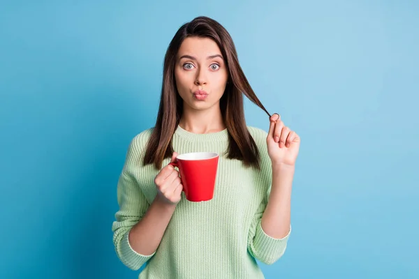 Foto de menina linda fazer lábios gordo segurar cappuccino copo toque penteado isolado sobre fundo de cor azul — Fotografia de Stock