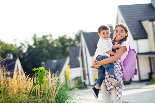 Foto retrato de hermanos felices hermana mayor sosteniendo al hermano menor al aire libre — Foto de Stock