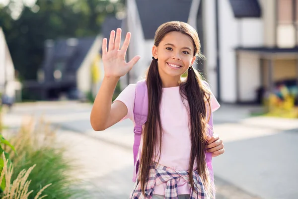 Fénykép portré kislányról integető kéz köszönés viselő hátizsák a szabadban — Stock Fotó
