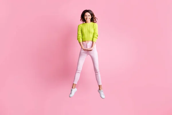 Teljes hosszúságú fotó csinos lány ugrás fogd a kezét viselni zöld pulóver nadrág tornacipő elszigetelt rózsaszín szín háttér — Stock Fotó