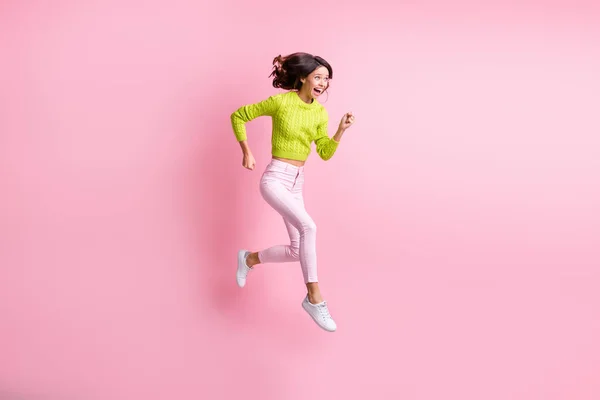 全长照片，可爱甜美的波浪式女士穿着绿色毛衣，跳着跑着跑着跑着跑着，带着淡淡的粉红背景 — 图库照片