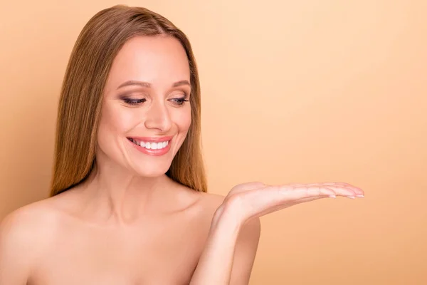 Primer plano retrato de agradable atractivo precioso desnudo alegre alegre alegre confiado recta chica sosteniendo en la palma copia espacio anuncio nueva novedad estética decisión aislada sobre fondo beige — Foto de Stock