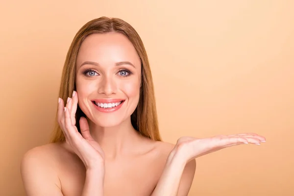 Primer plano retrato de agradable atractivo encantador perfecto desnudo desnudo alegre de pelo recto chica sosteniendo en el espacio de copia de la palma anuncio estética elevación aislado sobre fondo beige — Foto de Stock