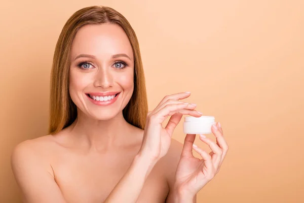 Primer plano ver retrato de ella ella bonita atractiva encantadora alegre dulce desnuda chica desnuda sosteniendo en la mano crema de la noche producto nuevo anuncio novedad aislado sobre fondo beige pastel — Foto de Stock