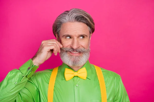 Фото смешного модного деда хитрый выражение лица кёрлинг идеальный усы смотреть кокетливые стороны носить зеленую рубашку желтые подтяжки бабочка галстук изолированы ярко розовый цвет фона — стоковое фото