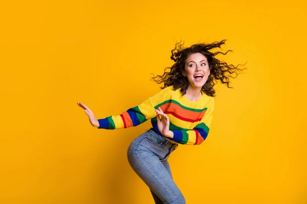 Photo of funny funky lady wearing casual colorful sweater dancing looking empty space isolated yellow color background