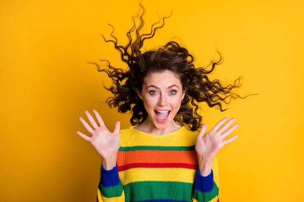 Foto de sorprendida mujer sorprendida vestida casual colorido sudadera viento soplado pelo abierto boca aislado color amarillo fondo — Foto de Stock