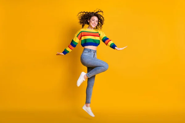 Foto de comprimento total da senhora saltando vestindo camisola colorida casual dançando apontando de pé uma perna isolado cor amarela fundo — Fotografia de Stock