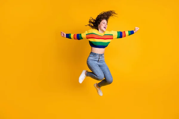 Volledige lengte foto van springende dame dragen casual kleurrijke trui handen armen kant gesloten ogen geïsoleerde gele kleur achtergrond — Stockfoto