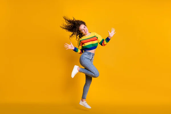Foto de comprimento total de mulher salto bonito vestido casual camisola colorida mostrando braços mãos palmas isolado cor amarela fundo — Fotografia de Stock