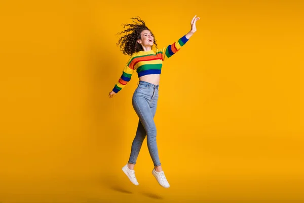 Lunghezza completa foto di dolce saltando signora indossa casual colorato maglione mano braccio fino isolato colore giallo sfondo — Foto Stock