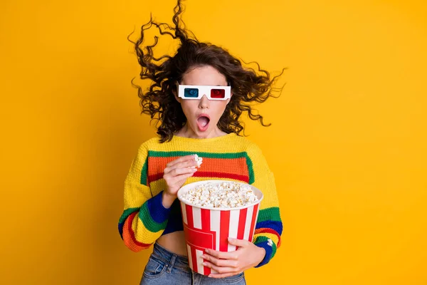 Photo of pretty shocked lady hold popcorn bucket watch movie thriller wear spectacles striped sweater isolated yellow background — Stock Photo, Image