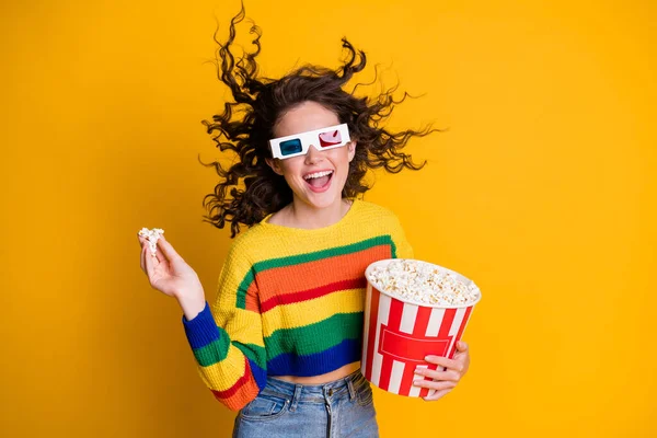 Photo of cheerful funny young lady hold popcorn bucket watch movie wear spectacles striped sweater isolated on yellow background — Stock Photo, Image
