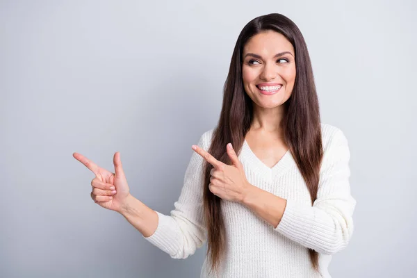 Retrato de encantadora chica de pelo castaño alegre demostrando copia vacía espacio en blanco anuncio aislado sobre fondo de color pastel gris —  Fotos de Stock