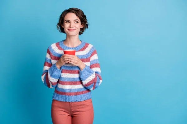 Photo portrait of cute sweet girl keeping red mug with beverage looking at empty space isolated on vibrant blue color background — Stock Photo, Image