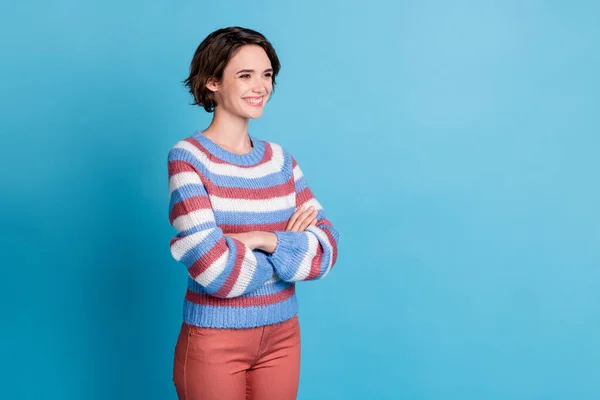 Profile photo of lovely girl crossed arms look empty space wear colorful striped pullover red pants isolated blue color background — Stock Photo, Image