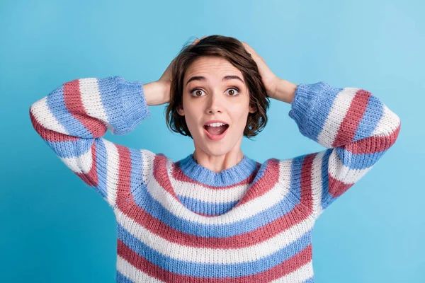 Photo of young cute lady hands behind head open mouth wear colorful striped sweater isolated blue color background — Stock Photo, Image