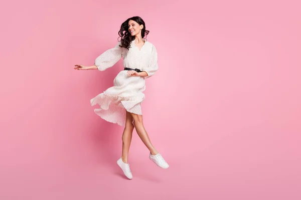 Pleine longueur taille du corps photo de la femme dansante en robe à pois longues sautant à la recherche d'espace vide isolé couleur rose pastel fond — Photo