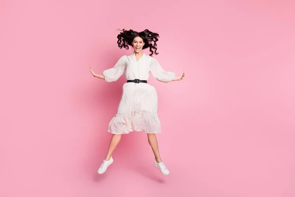 Ganzkörpergröße Foto von unbeschwerten verspielten Frau in weißem Kleid springen lächelnd isoliert pastellrosa Farbe Hintergrund — Stockfoto