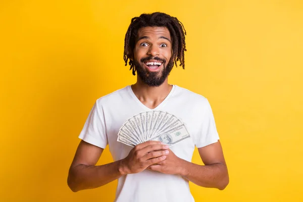 Photo of young black guy hold dollar money cash fan wear white t-shirt isolated yellow color background — Stock Photo, Image