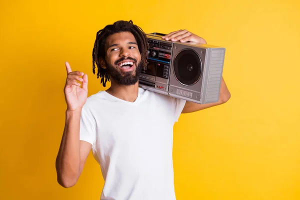 Joven chico negro levantar el dedo hacia arriba mirada espacio vacío mantenga grabadora vintage boca abierta desgaste blanco camiseta aislado color amarillo fondo —  Fotos de Stock