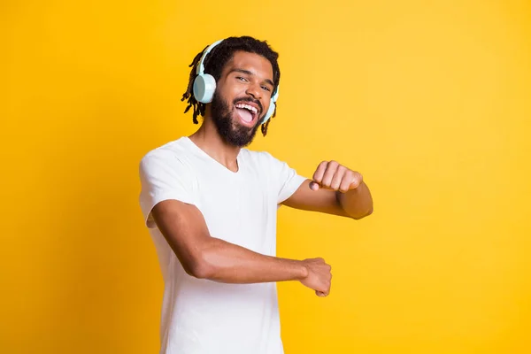Photo de jeune homme noir dansant bouche ouverte excité porter casque blanc t-shirt isolé fond de couleur jaune — Photo